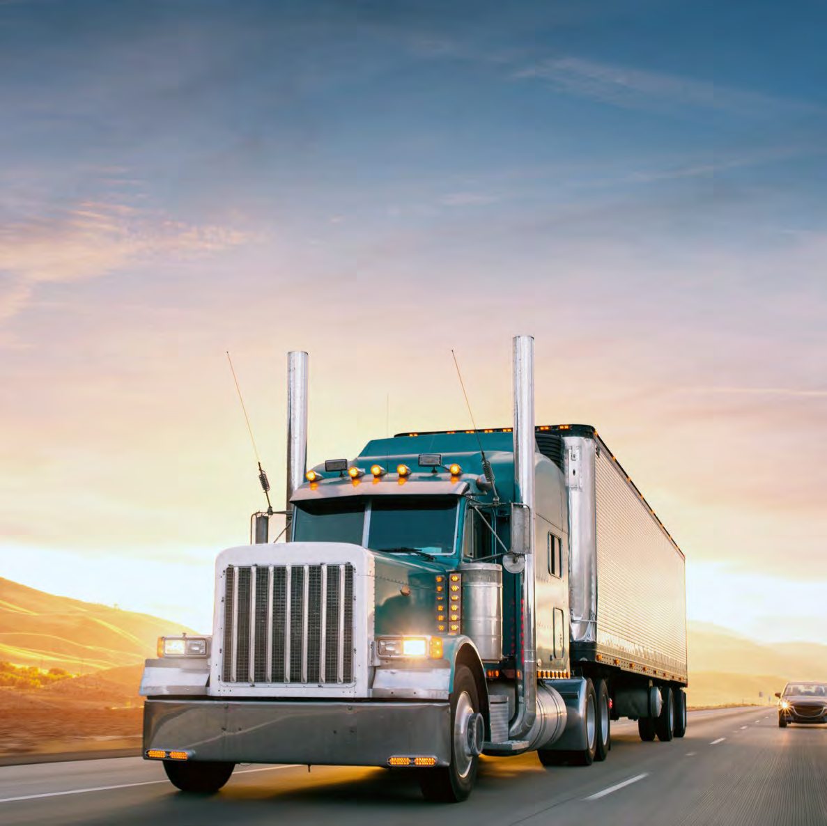 Heavy truck hauling a trailer on the highway at dawn